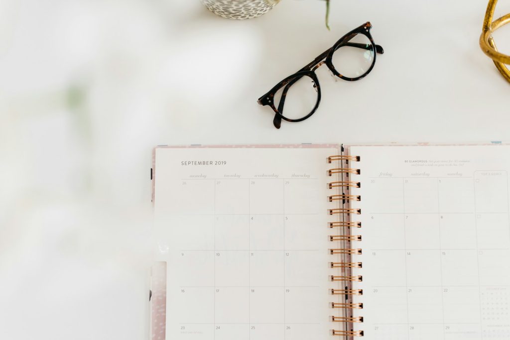 agenda semanal junto a unas gafas para organizar el tiempo de estudio de inglés
