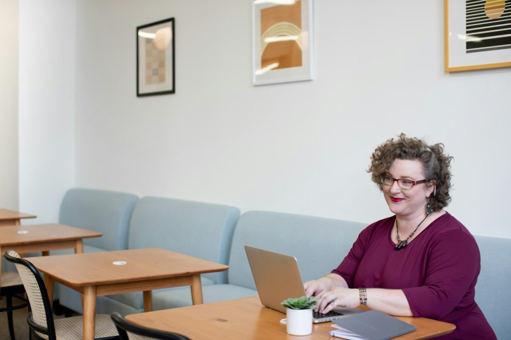 mujer adulta sonriendo con un portátil retomando el inglés