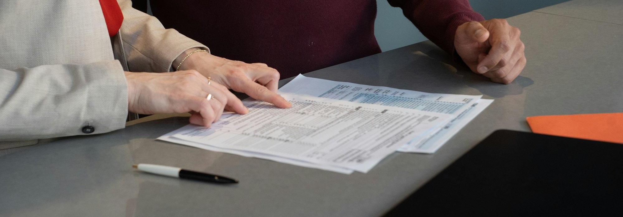 Dos personas revisando documentos en una mesa